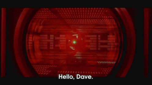 Cena de 2001: Uma odisseia no espaço. No GIF, é possível ver um tripulante flutuando no ar através das lentes vermelhas do computador HAL 9000. A legenda do GIF é: Olá,Dave. 